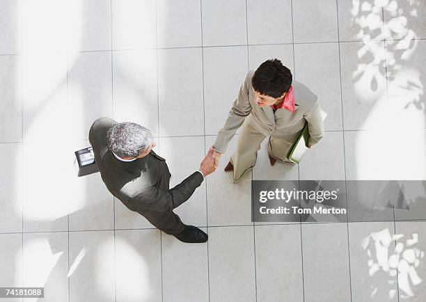 overhead view of businessman and businesswoman shaking hands - employee onboarding stock pictures, royalty-free photos & images