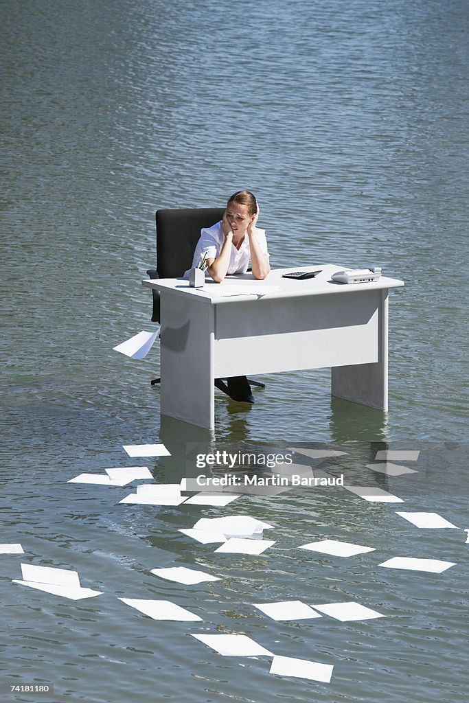 Paperwork Float Businesswoman Sitting At Desk In Water With Paperwork Floating Away ...