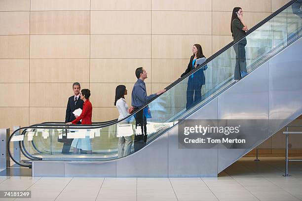 geschäftsleute auf rolltreppe - escalator stock-fotos und bilder