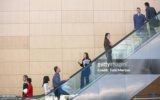 businesspeople on escalator - escalator side view stock pictures, royalty-free photos & images