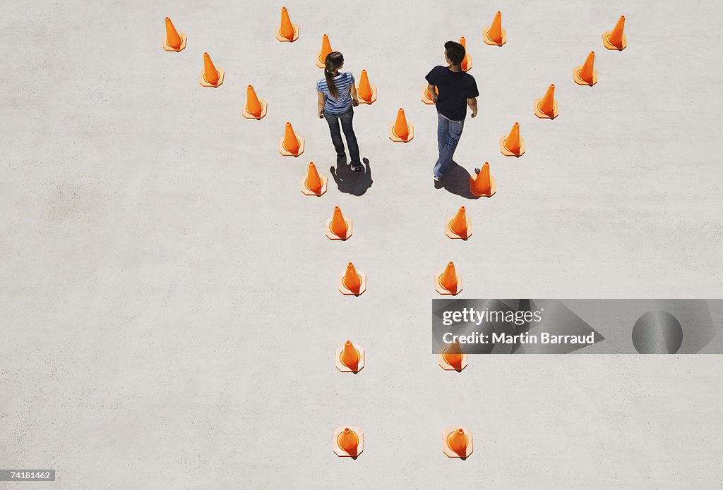 Man and woman in traffic cones moving apart