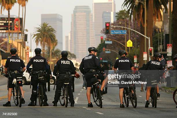 Police officers lead the way as protesters hold a march and rally denouncing the actions of Los Angeles riot police at a May Day immigrant rights...