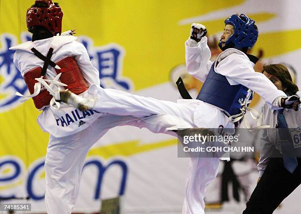 China's Wu Jingyu and Thailand's Yaowapa Boorapolchai exchange kicks during the women's 47kg final in the World Taekwondo Championship in Beijing, 18...