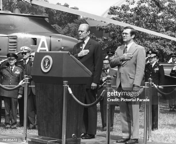 President Gerald Ford and US Secretary of Defence Donald Rumsfeld salute as the colour guards pass by at the opening of Armed Forces Week in...