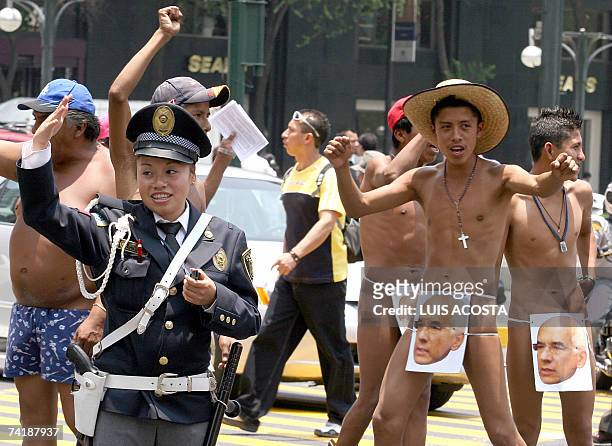 Naked peasants, members of the "400 Pueblos" organization, protest while a traffic police controls the traffic in the streets of Mexico City, 18 May...
