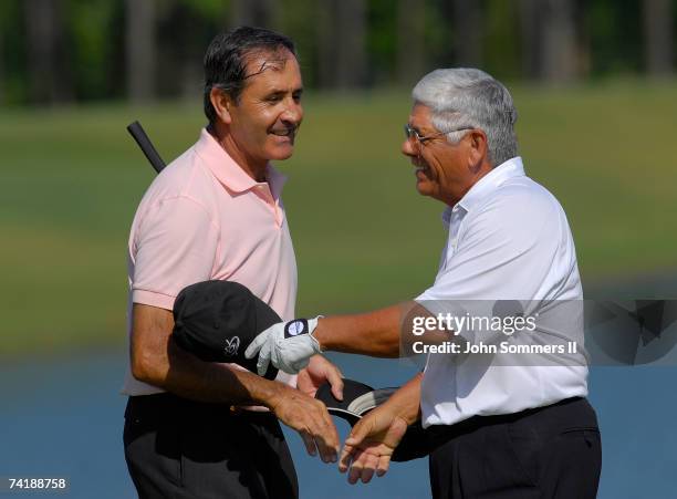 Seve Ballesteros of Spain shakes hands with Lee Trevino after putting out on the 18th green during the first round of the Regions Charity Classic at...