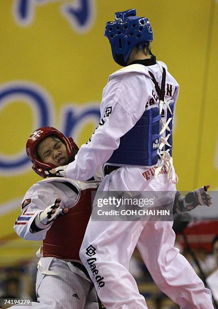 Thailand's Watcharaporn Dongnoi falls after executing a kick towards Turkey's Hamide Bikcin in the women's under 59kg semifinal bout of the World...