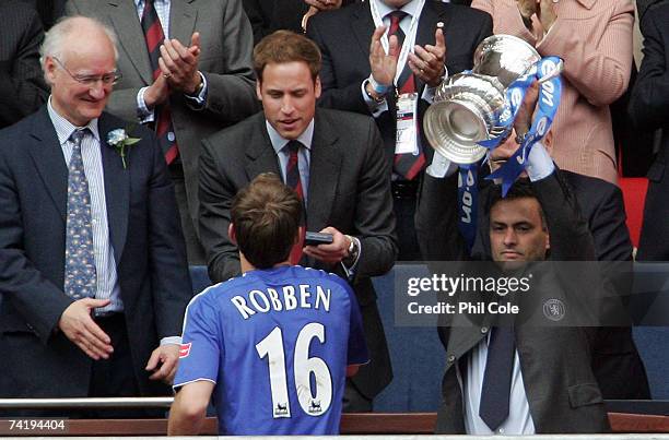 Jose Mourinho manager of Chelsea lifts the FA Cup trophy as HRH Prince William gives Arjen Robben his medal following the FA Cup Final match...