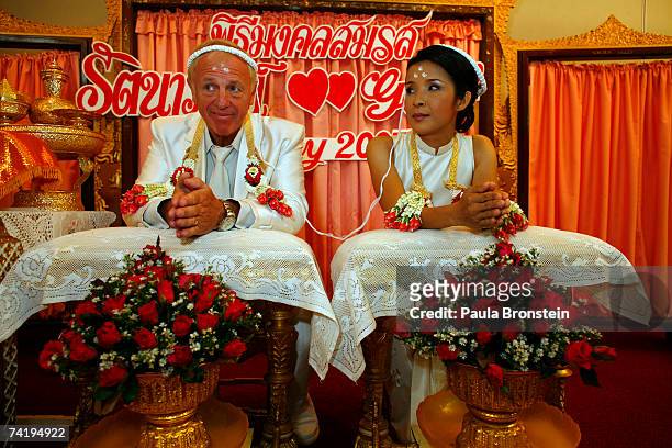 British groom Geoffrey Goodwin and Thai bride Ratanaporn sit during their traditional Thai wedding ceremony May 19, 2007 in Bangkok, Thialand. The...