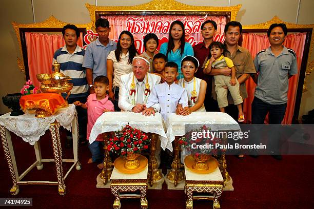 British groom Geoffrey Goodwin poses with his wife's family, his new stepson, Sorawi and his Thai bride Ratanaporn during their traditional Thai...