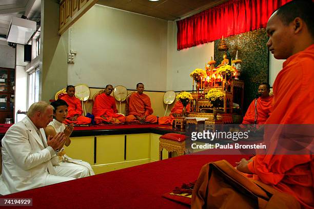 British groom Geoffrey Goodwin and Thai bride Ratanaporn pray to the monks during their traditional Thai wedding ceremony May 19, 2007 in Bangkok,...
