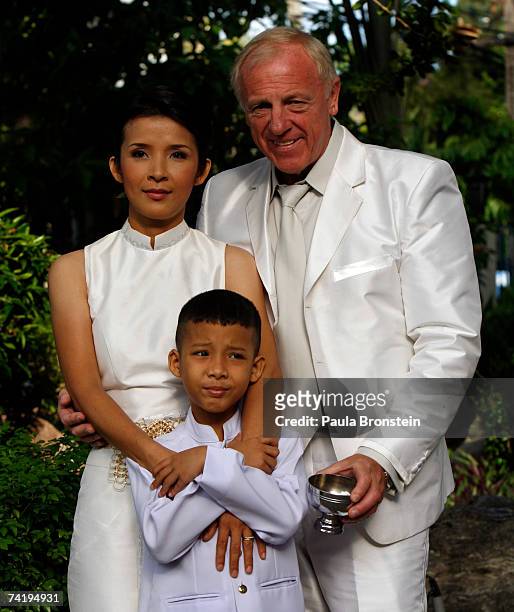 British groom Geoffrey Goodwin poses with his new stepson, Sorawi and Thai bride Ratanaporn after their traditional Thai wedding ceremony May 19,...