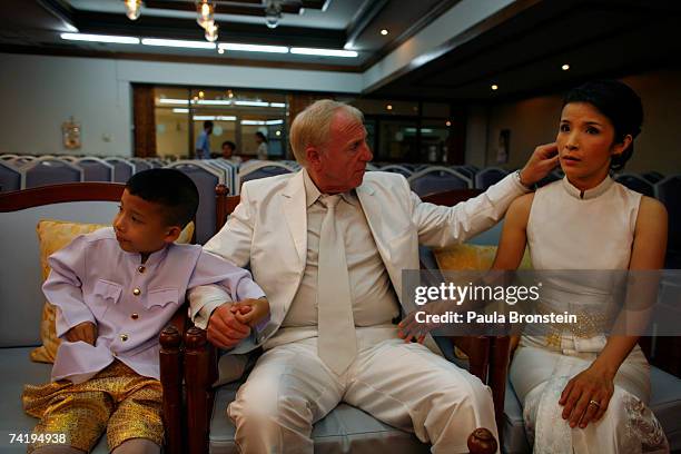 British Groom Geoffrey Goodwin holds hands with his new stepson, Sorawi and his Thai bride Ratanaporn at their traditional Thai wedding ceremony May...