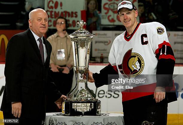 Captain Daniel Alfredsson of the Ottawa Senators poses with the Prince of Wales trophy and Deputy Commissioner of the NHL, Bill Daly, after the...