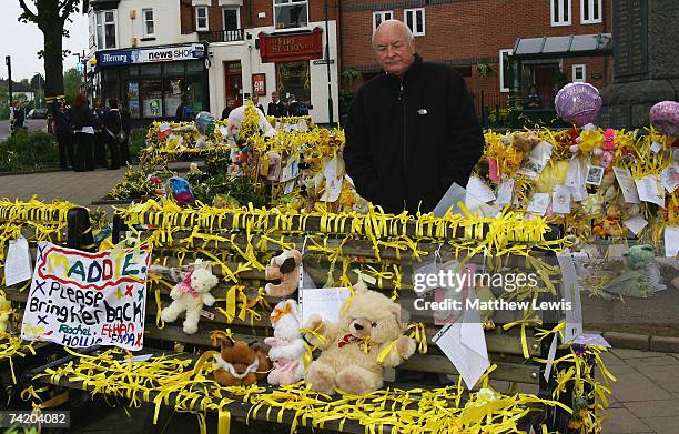 Brian Kennedy, the great uncle of missing child Madeleine McCann, stands amongst the messages of support at the War memorial in Rothley Village...