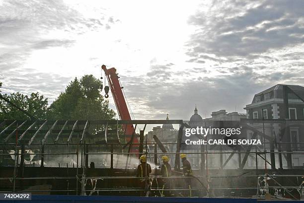 London, UNITED KINGDOM: Firefighters attempt to extinguish a fire on board the ship Cutty Sark, the world's last remaining tea clipper, in Greenwich,...