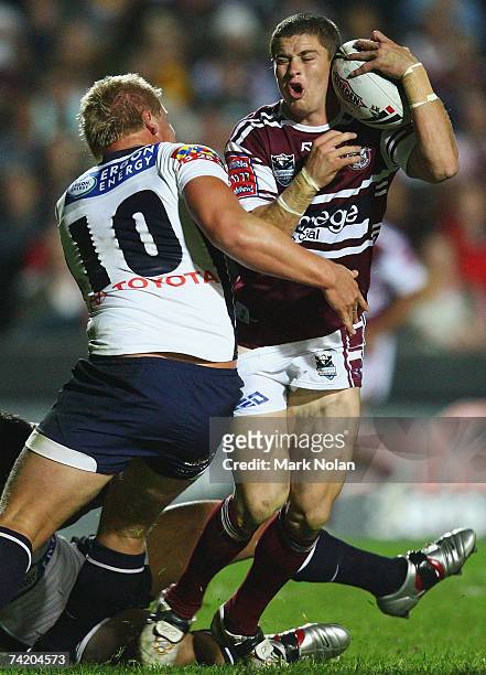 Travis Burns of the Eagles is tackled by Ben Hannant of the Broncos during the round 10 NRL match between the Manly Warringah Sea Eagles and the...