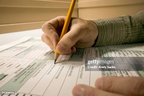 man marking election ballot with pencil, close-up of hands - stembiljet stockfoto's en -beelden