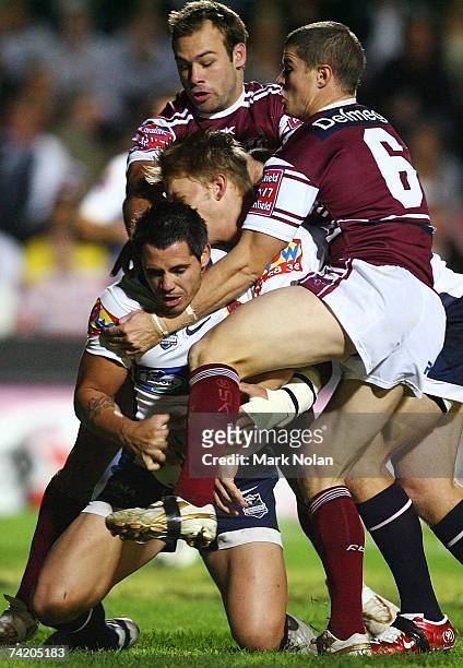 Corey Parker of the Broncos is tackled in goal by Brett Stewart and Travis Burns of the Eagles during the round 10 NRL match between the Manly...