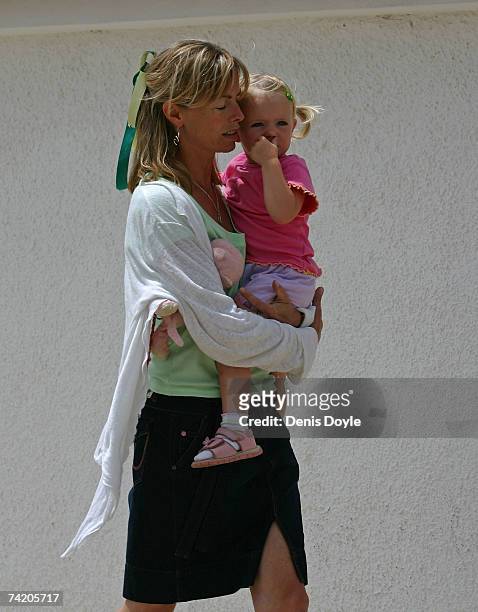 Kate McCann, the mother of missing girl Madeleine, carries her daughter Amelie back to their apartment on May 21, 2007 in Praia da Luz, Portugal....