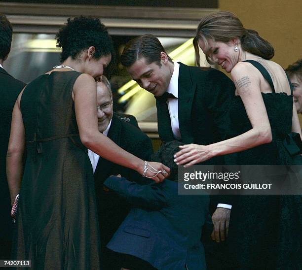 Actress Angelina Jolie and actor and producer Brad Pitt and Cannes Film Festival director Thierry Fremaux play 21 May 2007 with French journalist and...