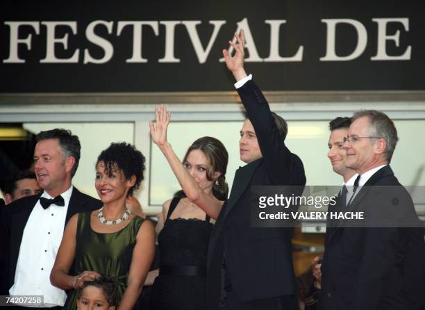 Actress Angelina Jolie and actor and producer Brad Pitt waves to fans 21 May 2007 as they pose with British director Michael Winterbottom , French...