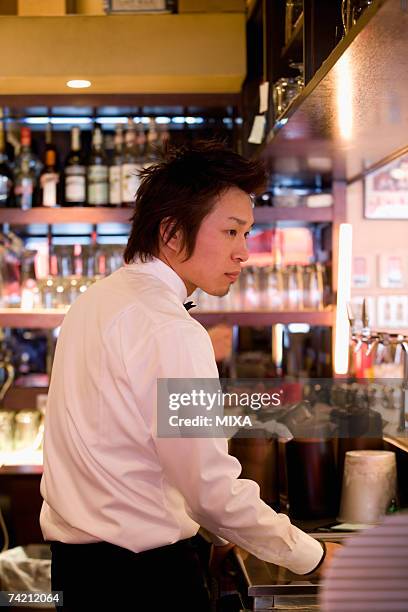 waiter standing behind bar counter - behind bar counter stock pictures, royalty-free photos & images