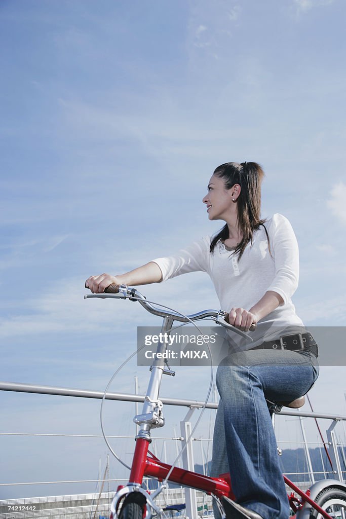 Young woman cycling on pier