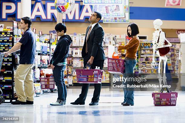 four people and a skeleton in grocery store lineup - supermarket queue stock pictures, royalty-free photos & images