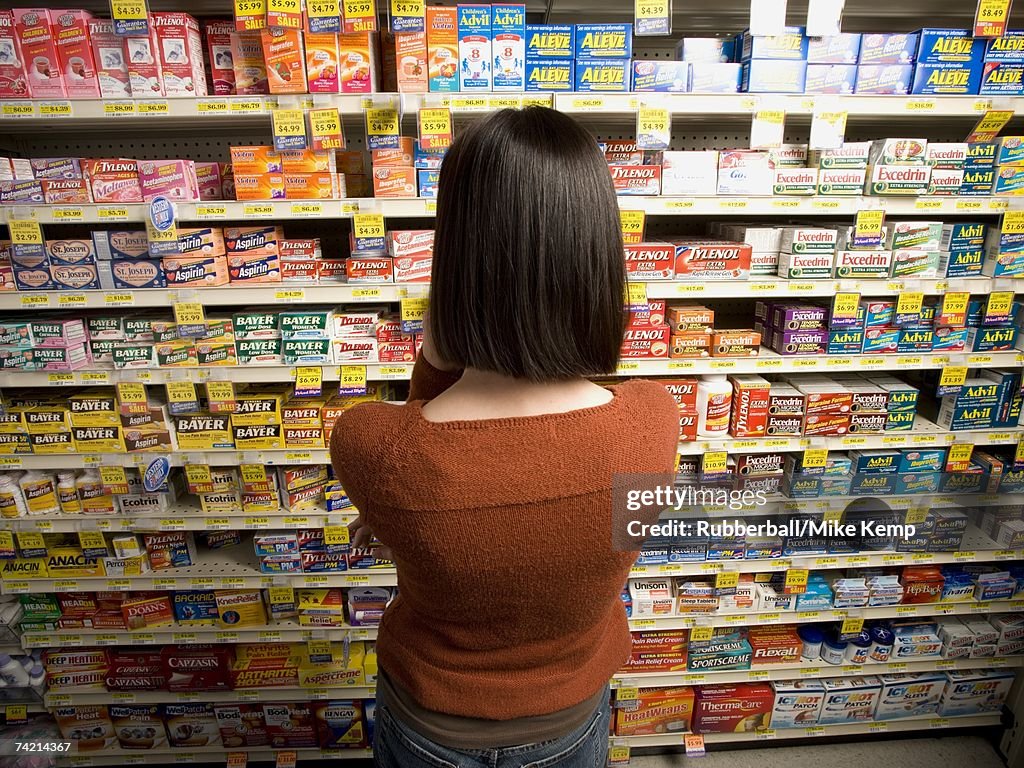 Rear view of woman in medicine aisle