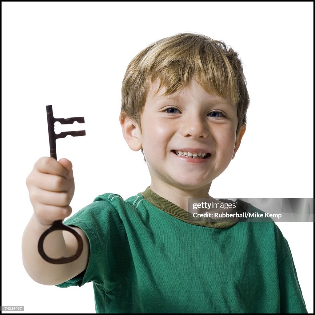 Young boy holding skeleton key smiling