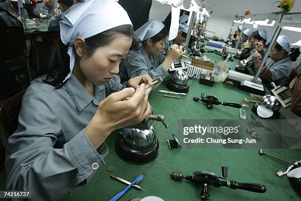 North Korean women work at the assembly line of the factory of South Korean Watch company Romanson at the Kaesong industrial complex on May 22, 2007...