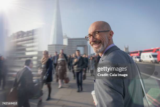 portrait smiling businessman walking on busy urban sidewalk, london, uk - personas en el fondo fotografías e imágenes de stock