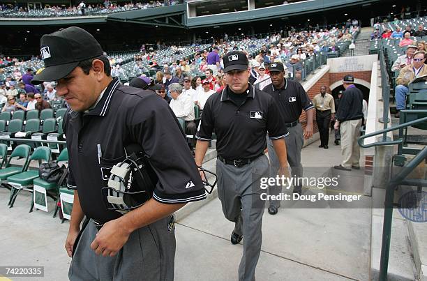 Umpires Alfonso Marquez, Tim Timmons and Chuck Meriwether walk onto the field before the Colorado Rockies game against the Arizona Diamondbacks at...