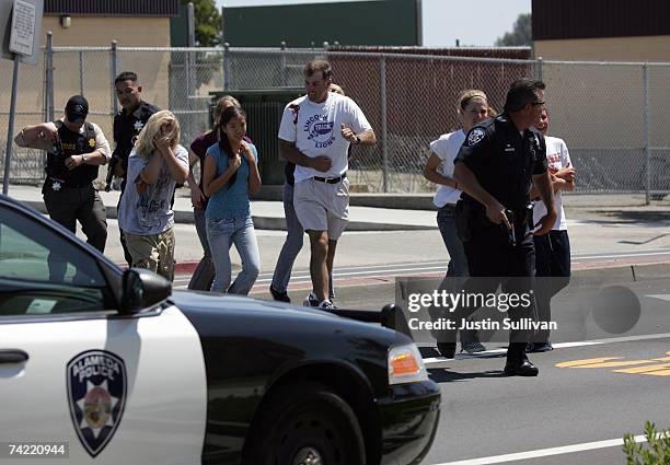 An Alameda Police officer evacuates volunteer students wearing makeup to simulate injuries during a school shooting and mass evacuation drill at...