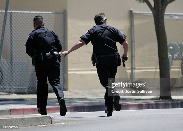 Alameda Police officers run towards a building as they respond to a school shooting and mass evacuation drill at Lincoln Middle School May 22, 2007...