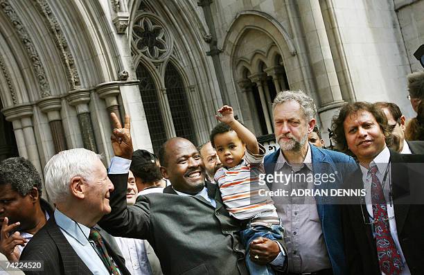 London, UNITED KINGDOM: Louis Olivier Bancoult, Chairman of the Chagos Refugees Group, holds his grandson Julien aloft outside The High Court in...