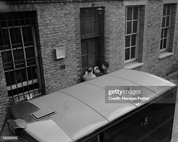 John Christie is taken into West London Police Court for his second remand hearing, 8th April 1953. Christie is accused of his wife's murder at 10...