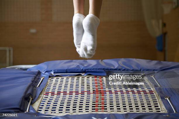 "child (11) jumping on trampoline, low section" - school gymnasium stockfoto's en -beelden