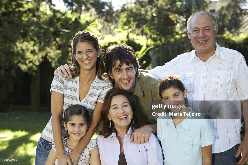 Three generation family including children (7-11) in garden, portrait
