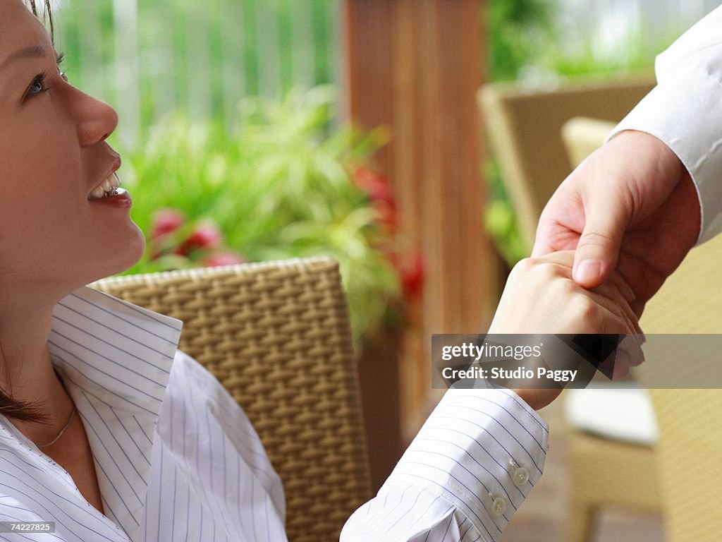 Close-up of a businesswoman shaking hands with a person