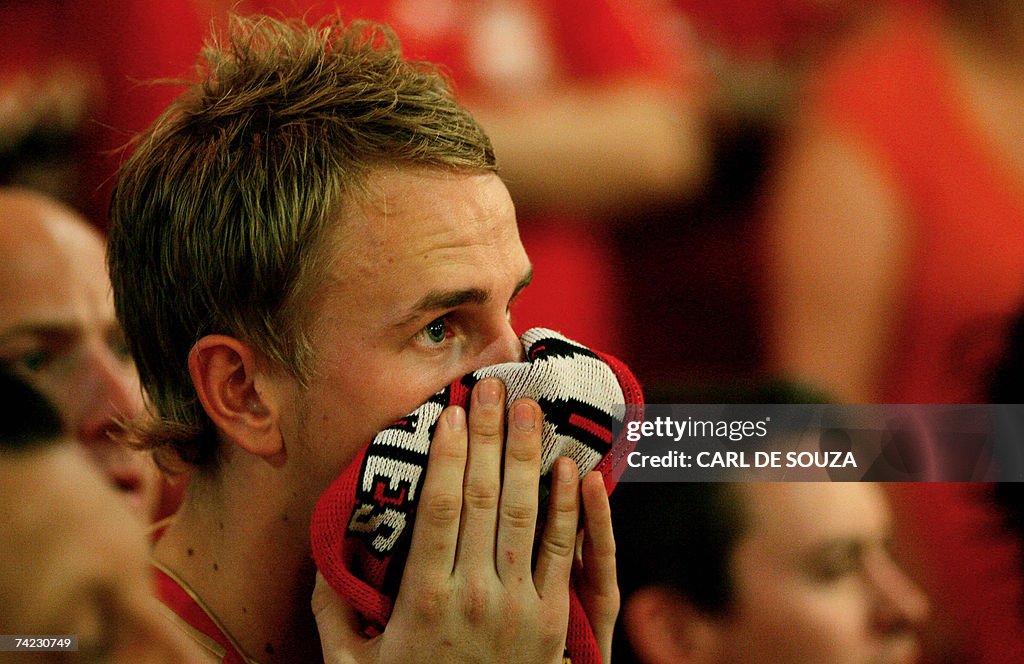 A Liverpool Football Club fan watches te...