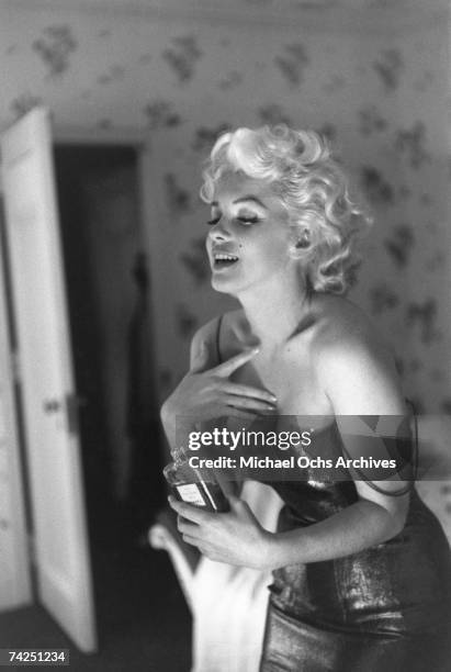 Actress Marilyn Monroe gets ready to go see the play "Cat On A Hot Tin Roof" playfully applying her make up and Chanel No. 5 Perfume on March 24,...
