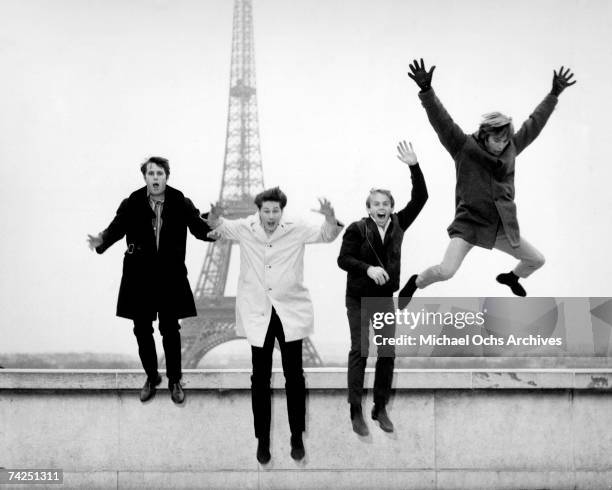 Rock and roll band "The Beach Boys" jump off a ledge in front of the Eiffel Tower in November 1964 in Paris, France.