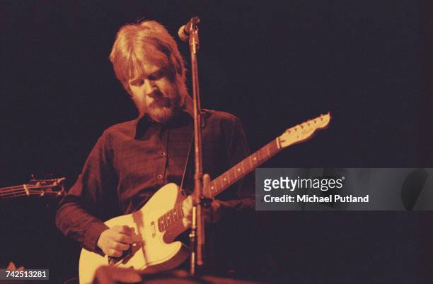 English musician and rhythm guitarist with English pub rock band Brinsley Schwarz, Ian Gomm performs live on stage playing a Fender guitar with the...