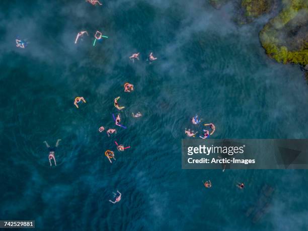 Secret Lagoon- Natural Hot Springs, Fludir, Iceland.  Aerial view of people swimming in a natural hot spring known as The Secret Lagoon, located near the small village of Fludir, a short drive from Reykjavik, Iceland. This image is shot using a drone. 