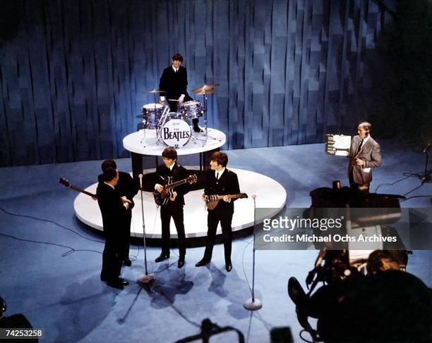 Elevated view of American television personality Ed Sullivan , with the members of British Rock group the Beatles, during an episode of 'The Ed...