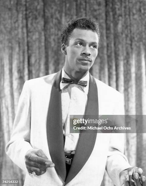 Rock and roll musician Chuck Berry performs onstage wearing a tuxedo with a bow tie in circa 1957.