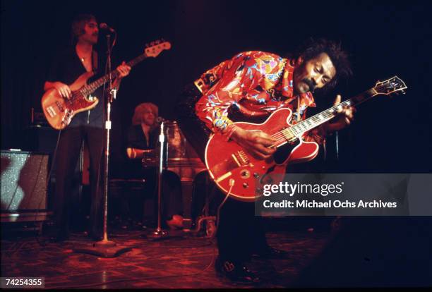 Rock and roll musician Chuck Berry performs onstage with a Gibson hollowbody electric guitar with a bass player and piano player in circa 1970.