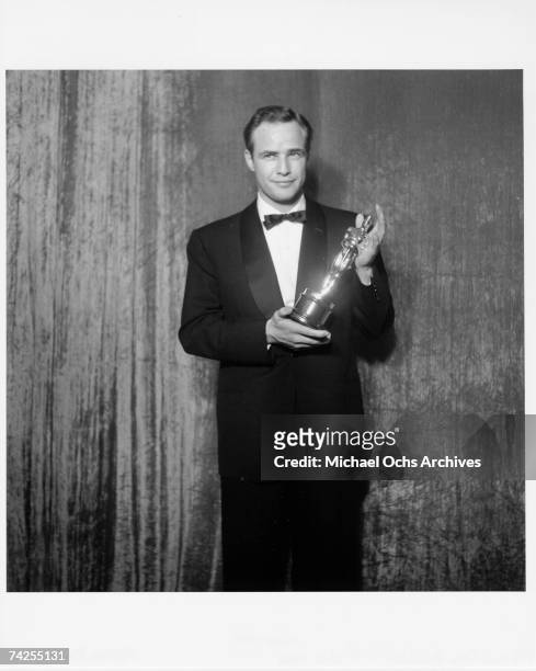 Best actor winner Marlon Brando poses backstage at the 27th Academy Awards holding an Oscar for his performance in the movie "On The Waterfront" on...